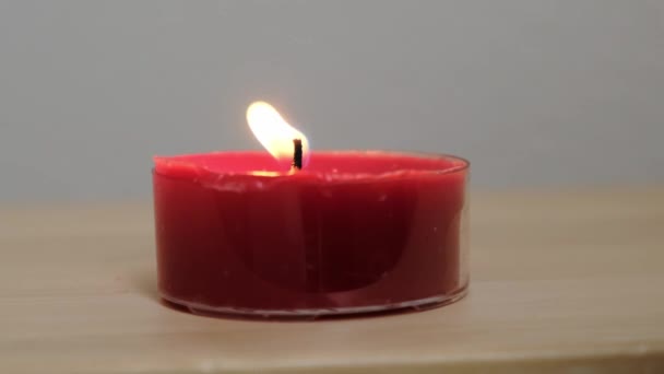 Hermoso fuego de una vela en un cuarto oscuro. De cerca. . — Vídeos de Stock