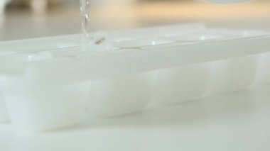 Taze içme suyunu bir sürahide buz kalıbına döküyorum. Kapat..