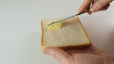 Man Use Knife and Spread White Butter on aBread in Slow Motion. Close up.