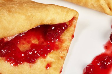 Beyaz tabakta kırmızı reçelli krep. Kapat..