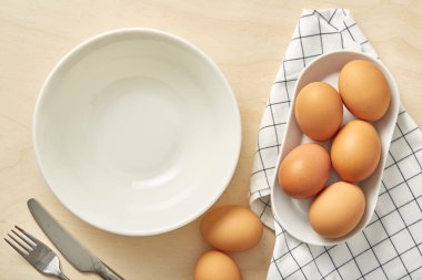 Ahşap arka planda beyaz kâseli çiğ tavuk yumurtası. Kapat..