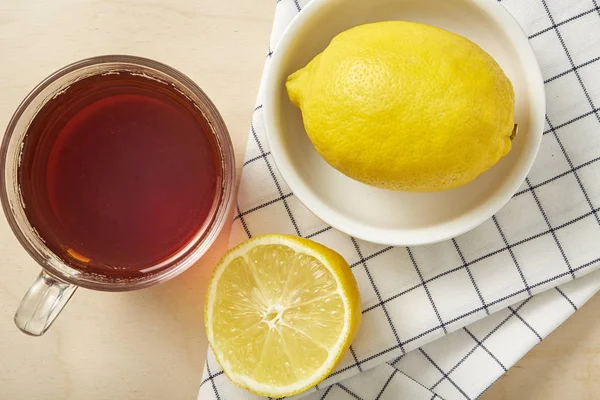 Black tea with lemon on the wooden background. Top view. — Stock Photo, Image