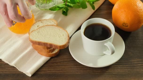 Engarrafamento de café da manhã saboroso e saudável em pão crocante. O homem faz uma sanduíche. Fechar . — Vídeo de Stock