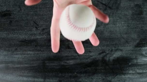 Lanzando una pelota de béisbol sobre fondo negro de madera. De cerca. . — Vídeos de Stock