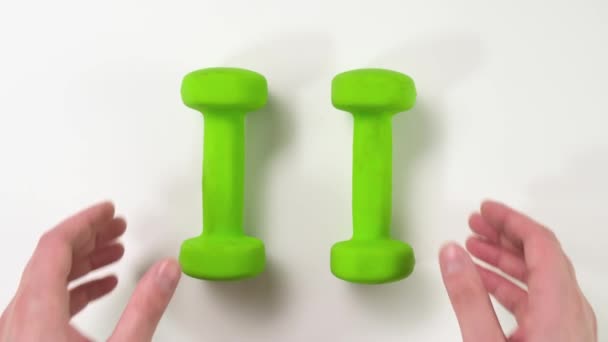 Hand with green Dumbbells on white background. Close up, — Stock Video
