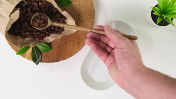 Vista superior de la mano persona tomar granos de café en el plato. De cerca. . — Vídeos de Stock