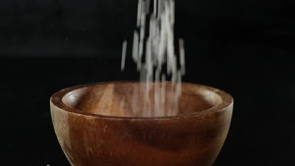 Cuenco de madera relleno con arroz sobre fondo negro. De cerca. . — Vídeos de Stock