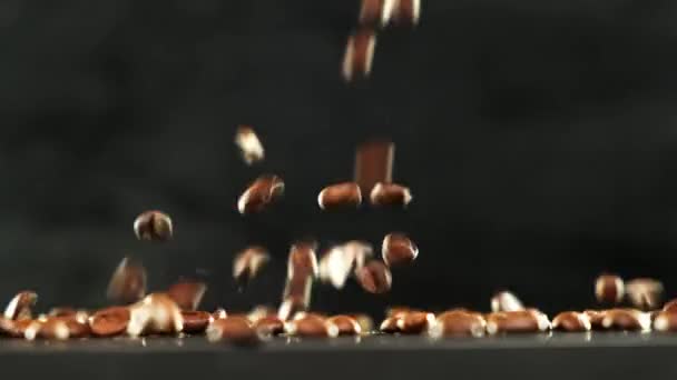 Falling Coffee Beans auf schwarzem Hintergrund. Nahaufnahme. — Stockvideo