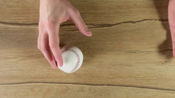 Jogando uma bola de beisebol no fundo preto de madeira. Fechar . — Vídeo de Stock