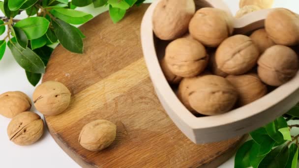 Walnuts in bowl on wood chopping board kitchen table. Close up. — Stock Video