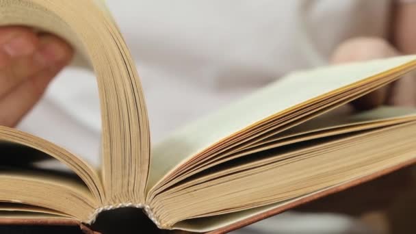 Homme retournant des pages dans le livre pour la navigation. Gros plan .