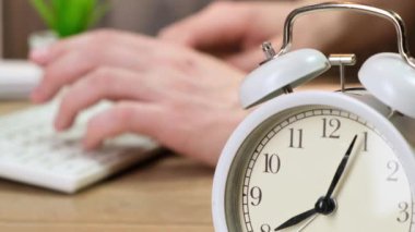 Ofiste alarm ötüyor. Arka planda klavyede yazan adam. Kapat..