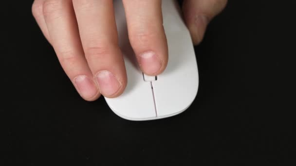 Muž ruka používá bílou bezdrátovou myš na černém stole. Zavřít. — Stock video