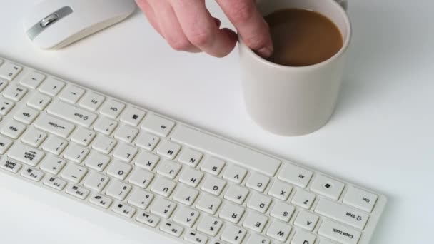 Una taza de café tirada en el teclado blanco. De cerca. . — Vídeos de Stock
