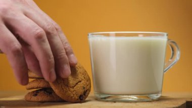 Chocolate cookies on wooden boar and glass of milk. Close up