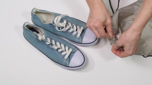 Hand puts sneakers in a bag. Indoor shoes. Close up. — Stock videók