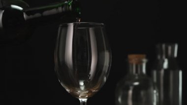 Skilled sommelier pouring red wine from bottle into Glass. Close up.