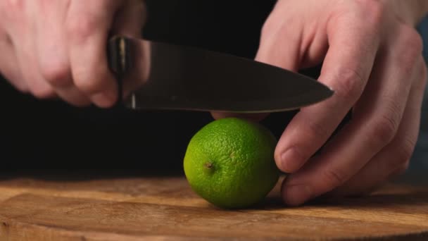 Corte em limão meio fresco com faca em tábua de corte de madeira. Fechar . — Vídeo de Stock