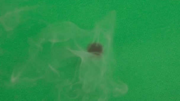 Fire burns green paper from the middle of the sheet. Close up — Stock Video