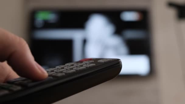 Mão masculina segurando remotamente o controle swith na tv inteligente. Fechar . — Vídeo de Stock