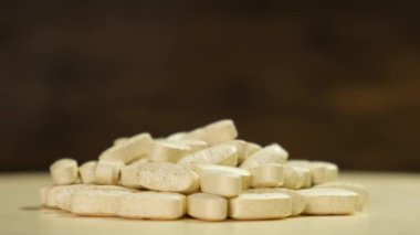 Tablets, medicinal pill are on the rotating on Black background. Close up.