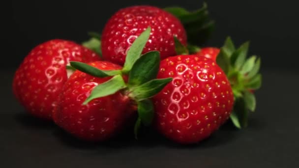 Fresh Strawberry rotating on a black background. Close up. — Stock videók