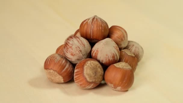 Hazelnut rotating on a wooden background. Close up. — ストック動画