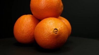 Orange fruit rotating on a black background. Close up