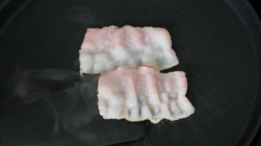 Kızartma tavasında çiğ domuz pastırması. Kapat..