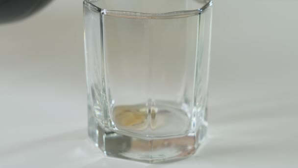 Verser le cola dans du verre sur une table blanche. Gros plan .