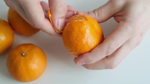 Mão Descascando Uma Mandarina Laranja Fundo Branco Fechar — Vídeo de Stock