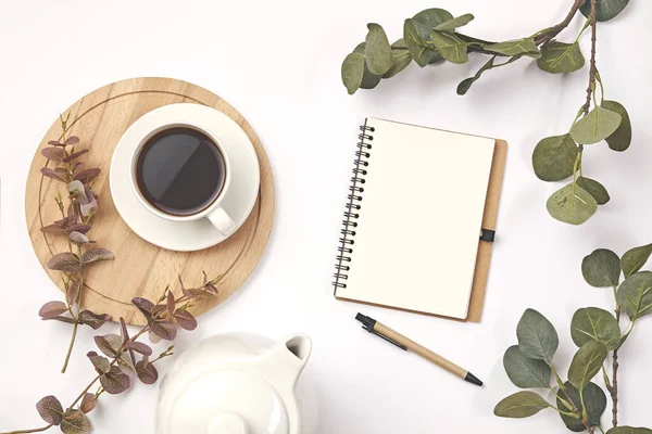 Tazza di caffè, matita, ramo con foglia, nota di carta su sfondo bianco . — Foto Stock