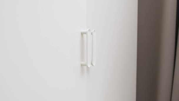 Handen öppen dörr av vit garderob. Närbild. — Stockvideo