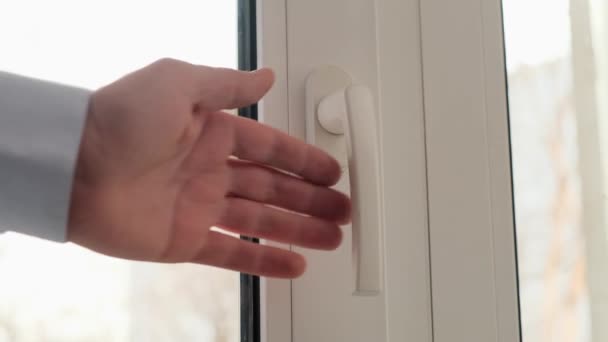 Een man opent een raam om de kamer te ventileren. Sluiten.. — Stockvideo