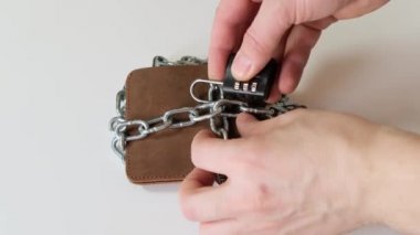 Zincirin altındaki cüzdanda kilitli para. Kapat..