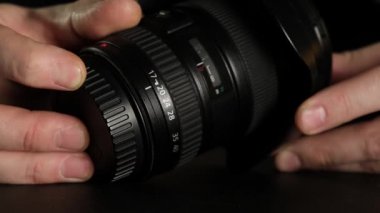 Bir erkeğin eli objektifin odak çarkını çevirir. Kapat..