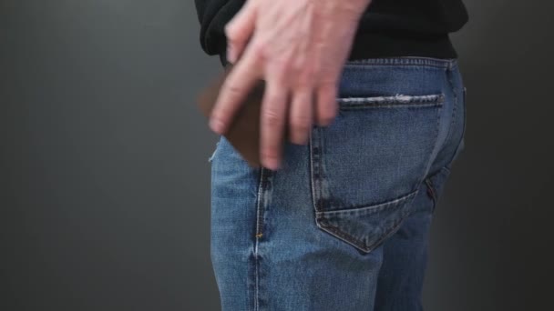 Рука положила бумажник в карман джинсов — стоковое видео