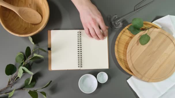 Blank note paper on wooden table with dishes. — Stock Video