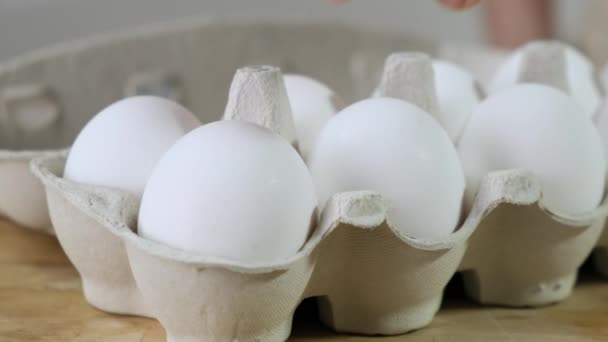 Hand neemt er een van eieren verpakt in karton — Stockvideo