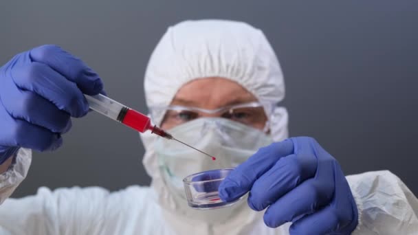 Asisten laboratorium memegang jarum suntik dengan darah. Tutup.. — Stok Video