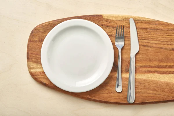 Empty plate and chopping board on table. Top view. — Stock Photo, Image