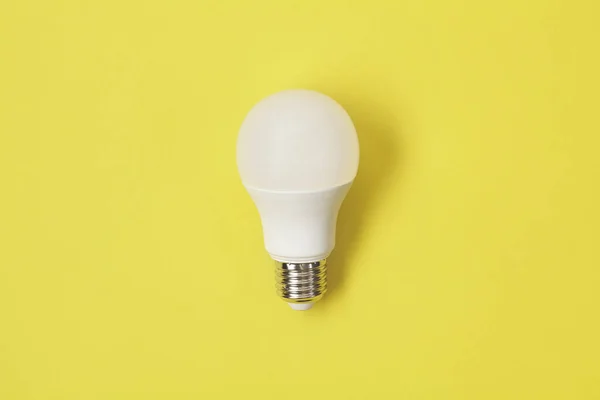 Energiebesparende lamp op gele rug. — Stockfoto