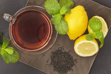 Çaylı, limonlu ve yeşil yapraklı bir fincan..