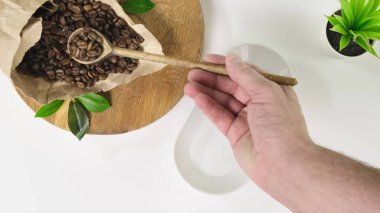 Person 'ın üst görüntüsü kahve çekirdeklerini tabağa koyuyor. Kapat..