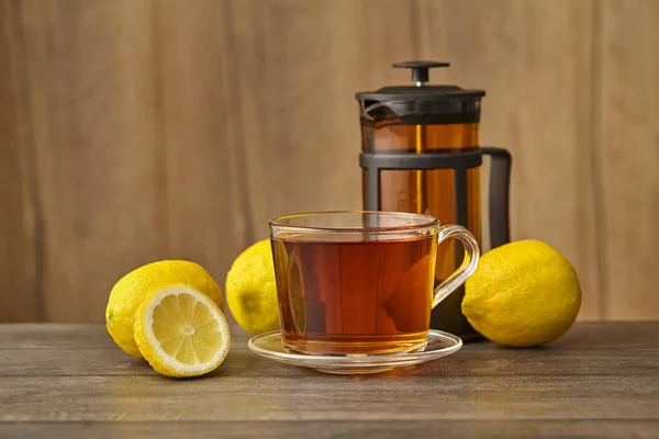 Glass cup of tea with lemon on table on light background — Stock Photo, Image