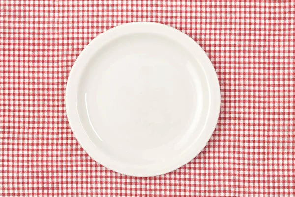 White empty plate on red checked tablecloth — Stock Photo, Image