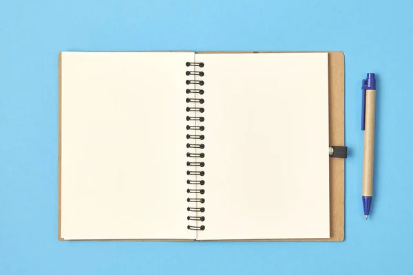 Carta bianca aperta con penna su sfondo blu. Vista dall'alto . — Foto Stock
