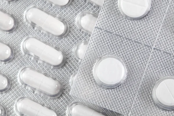 Vita tabletter i förpackningen. Apotek och medicin bakgrund. — Stockfoto