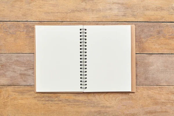 Notepad or notebook with on brown wood table background. Top view. — Stock Photo, Image