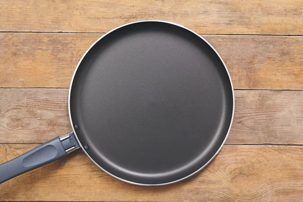 Frying pan on wooden table background. View from above. Close up — Stock Photo, Image